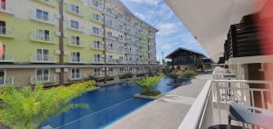 PusokJC SpaceRentals 127B Amani Grand Resort Residences, balcony pool view, Ground floor, 5 mins frm airport, free wifi, Netflix的享有酒店庭院和游泳池的景色