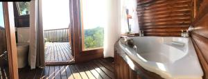 塞吉菲尔德特尼卡树峰酒店的带阳台的客房内设有带大浴缸的浴室