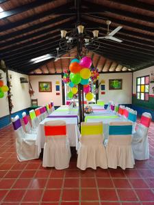 蒙特内哥罗Alojamiento rural finca estrella del Quindío的配有长桌、椅子和气球的房间