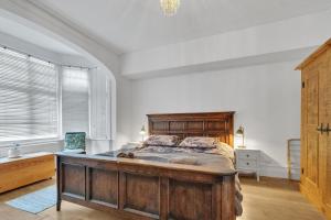 布莱顿霍夫Simply Hove By My Getaways的一间卧室设有一张大型木床和一个窗户。