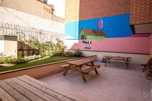 马德里TX Matadero的两把长椅和一幅壁画在建筑物的一侧