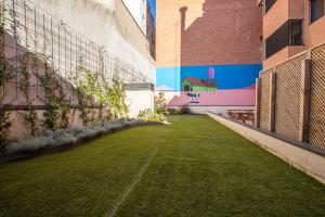 马德里TX Matadero的一座庭院,在建筑的一侧有草地和壁画