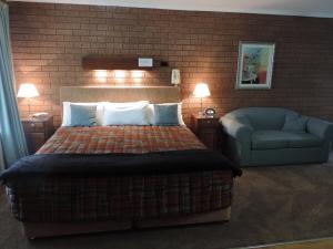 科罗瓦格林埃克斯汽车旅馆的一间卧室配有一张床、一张沙发和一把椅子