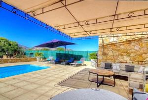 卡伦扎纳Villa terranga的一个带游泳池、椅子和遮阳伞的庭院