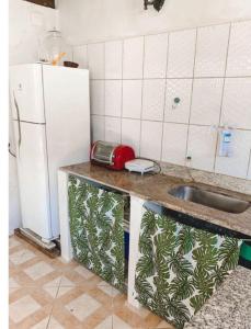 劳鲁-迪弗雷塔斯Suítes Vilas do atlântico a 100M da praia的厨房配有水槽和白色冰箱