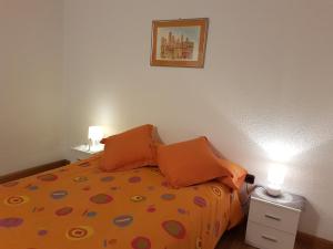 帕斯底拉卡萨内华达格瑞佛洼坎瑟斯公寓的一间卧室配有带橙色枕头的床