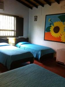 蒙特内哥罗Alojamiento rural finca estrella del Quindío的一间卧室配有两张床,并画着向日葵