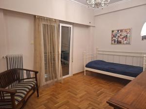 雅典Cozy apartment next to metro station的一间卧室配有一张床、一把椅子和一张桌子