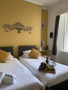托基Babbacombe Palms的酒店客房,配有两张带鲜花的床