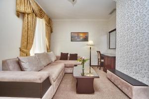 敖德萨皇家大街酒店的客厅配有沙发和桌子