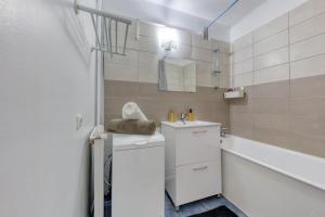 圣但尼Réconfort - 15 min de Paris的白色的浴室设有水槽和浴缸。