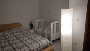波坦察IRIDEA COUNTRY的一间卧室设有两张婴儿床、一张床和一盏灯。