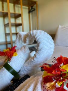 阿廷斯Oka Pousada Atins的床上的毛巾,鲜花盛开