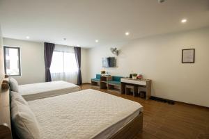 谅山ANH TU Hotel的酒店客房,设有两张床和一张沙发