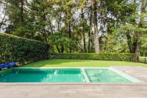 El PedregalHermosa Casa frente a campo de golf的庭院中的游泳池,带有树 ⁇ 