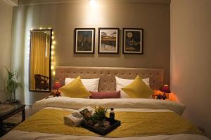大诺伊达Luxury Apartment Near Pari Chowk的一间卧室配有两张带黄色枕头的床