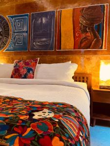 切图马尔Hotel "ala Residencias"的卧室配有一张床,墙上挂有绘画作品