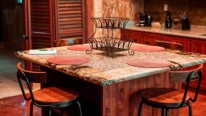 切图马尔Hotel "ala Residencias"的厨房岛配有四把椅子和台面