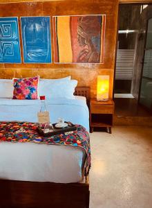 切图马尔Hotel "ala Residencias"的卧室配有一张床,墙上挂有绘画作品