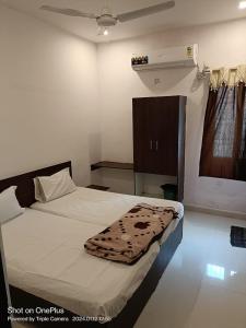 卡努尔Durga Pride的一间卧室配有一张床铺,床上有毯子