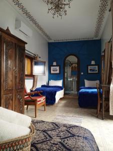 拉巴特RIAD Dar Ouezzani的一间卧室设有两张床和蓝色的墙壁