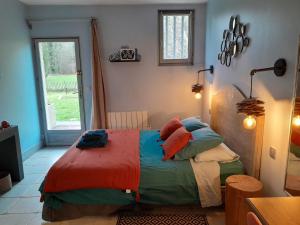 Avilly-Saint-Léonard勒布拉姆住宿加早餐旅馆的一间卧室配有一张带色彩缤纷的毯子和枕头的床。