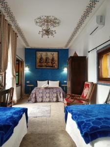 拉巴特RIAD Dar Ouezzani的一间蓝色卧室,配有两张床和吊灯