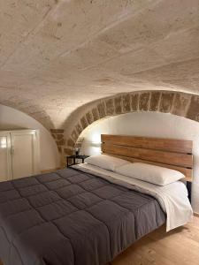 巴里L'Antica Dimora in Centro的卧室配有一张石墙内的大床
