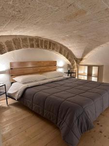 巴里L'Antica Dimora in Centro的卧室配有一张石墙内的大床