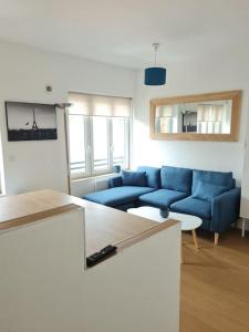 图尔昆Bel appartement 3 suites privatives hyper centre的客厅配有蓝色的沙发和桌子