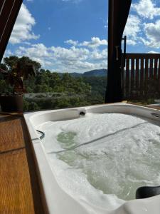 格拉玛多Reserva Linha Bonita的观景甲板上的按摩浴缸