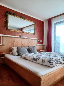 拉德施塔特Sonnhof的卧室配有一张大床,墙上装有镜子