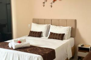 卡皮托利乌Shalom Pousada Capitólio的卧室配有带毛巾的大型白色床