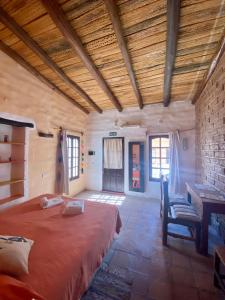普尔马马尔卡Hosteria La Pushka的卧室配有一张床和一张桌子及椅子