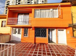 马尼萨莱斯Aparta Estudio nuevo a 2 calles de Milán的一座橙色的房子,设有白色门和砖地板