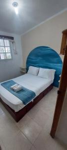 BejuqueroApto Los Blancos, a dos Minuto de los Patos的一间卧室配有一张大床和蓝色床头板