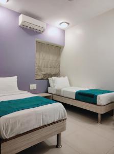 孟买Apollo Guest House的一间卧室设有两张床和窗户。