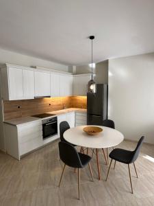 毕达哥利翁Olea Luxury Apartment的厨房配有桌椅和冰箱。