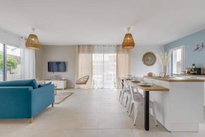 山地圣母村Clair Jeanne - Charmante maison neuve的厨房以及带桌子和蓝色沙发的客厅。