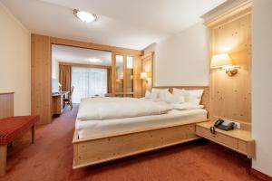 朗根费尔德丽塔酒店的一间卧室配有一张大床和一张书桌