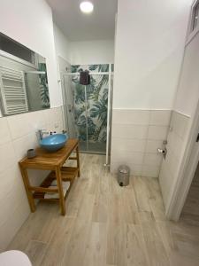 卡萨莱蒙费拉托La Casa nel Vicolo Camera 3的浴室设有木桌上的蓝色碗水槽