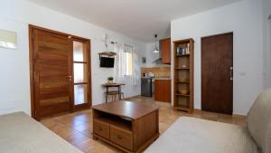 圣费兰-德瑟斯罗Apartaments ES POU的配有床和桌子的房间以及厨房