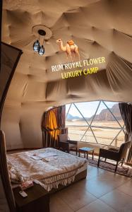瓦迪拉姆RUM ROYAL FLOWER lUXURY CAMP的一间房间,配有一张床和一个读过甲状腺花豪华营的标志