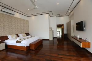 Hokandara SouthEden Gardens Residence的一间卧室配有一张床和一台平面电视