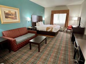 韦科近大学质量酒店及套房的酒店客房,配有床和沙发