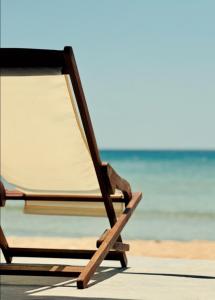 ProvatasCave Beach House Milos的海滩上的椅子,背景是大海