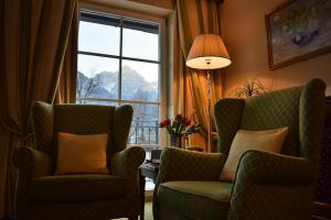 利恩茨Grandhotel Lienz Business-Wellness & Gourmet的客厅配有两把椅子和窗户