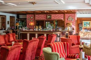 利恩茨Grandhotel Lienz Business-Wellness & Gourmet的餐厅内的酒吧,带红色椅子