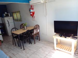GualeguaychúLa Delia的厨房配有桌椅和电视。