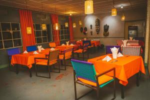 RuhengeriRoom in Guest room - Isange Paradise Resort的用餐室配有橙色桌椅